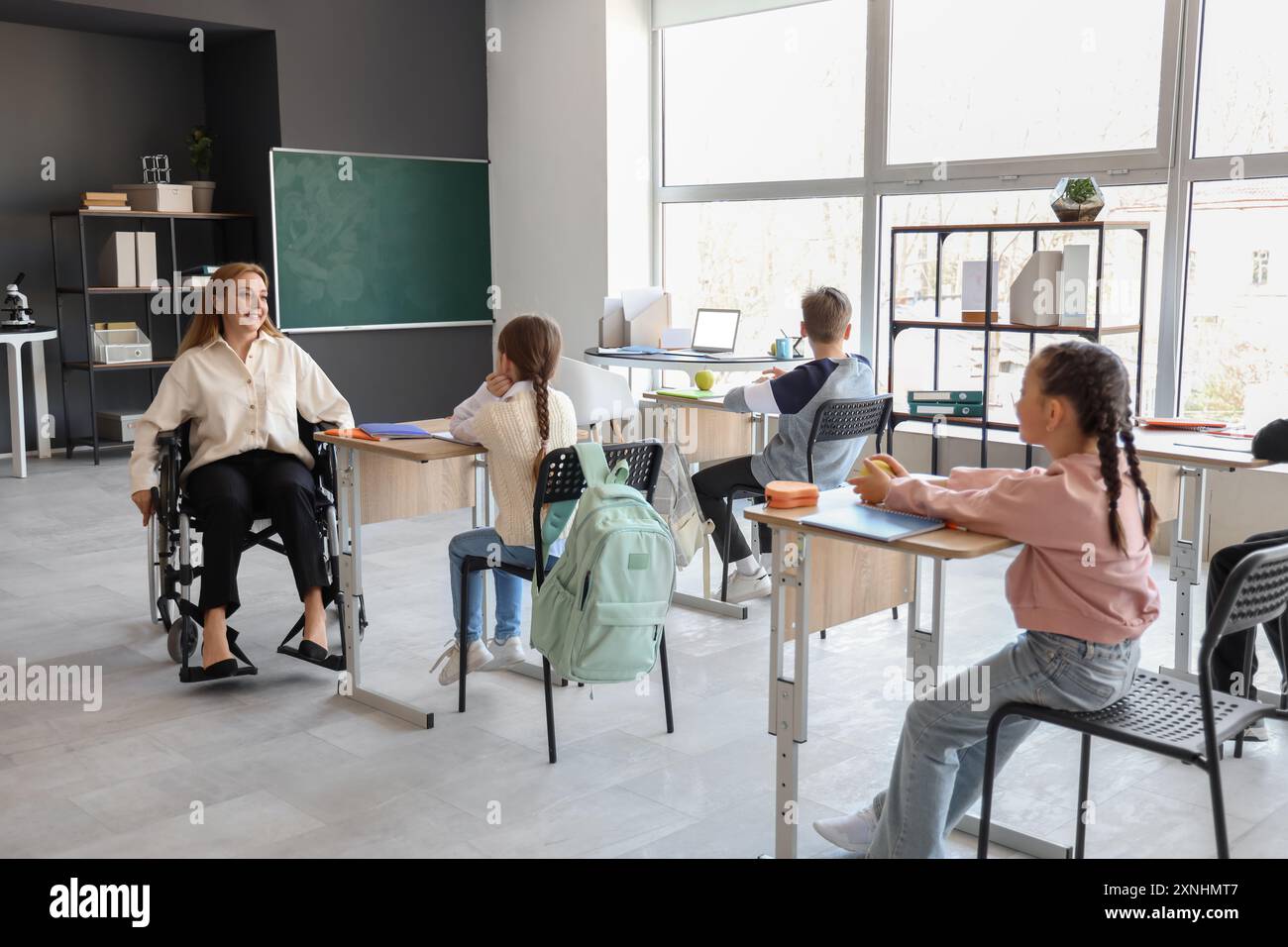Mature teacher in wheelchair conducting lesson at school Stock Photo ...