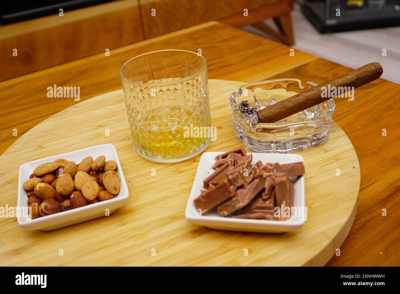 Cigar whiskey chocolate and nuts on wooden table close up view Stock Photo