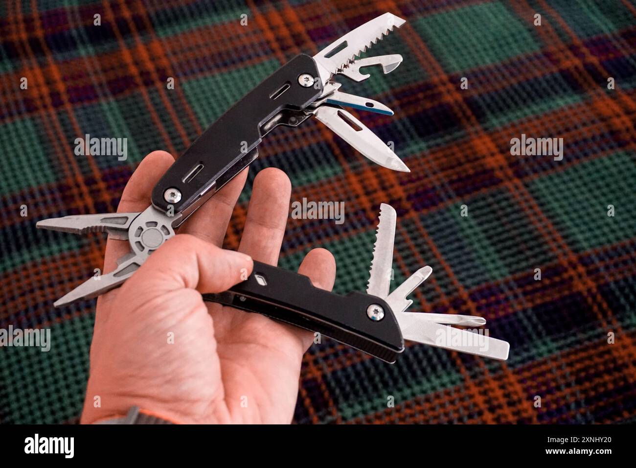 Man holding multi tool in hand close up view Stock Photo