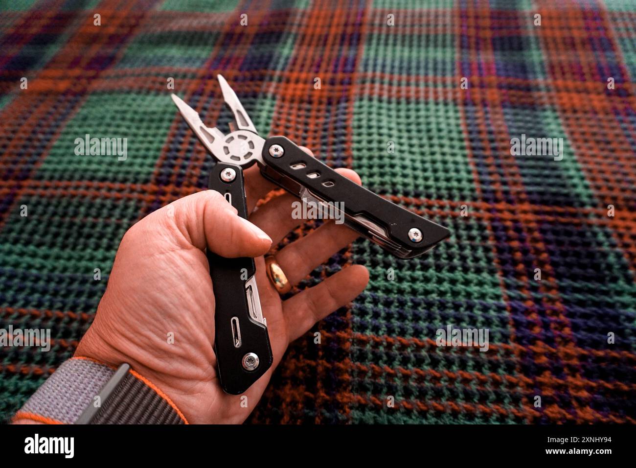 Man holding multi tool in hand close up view Stock Photo