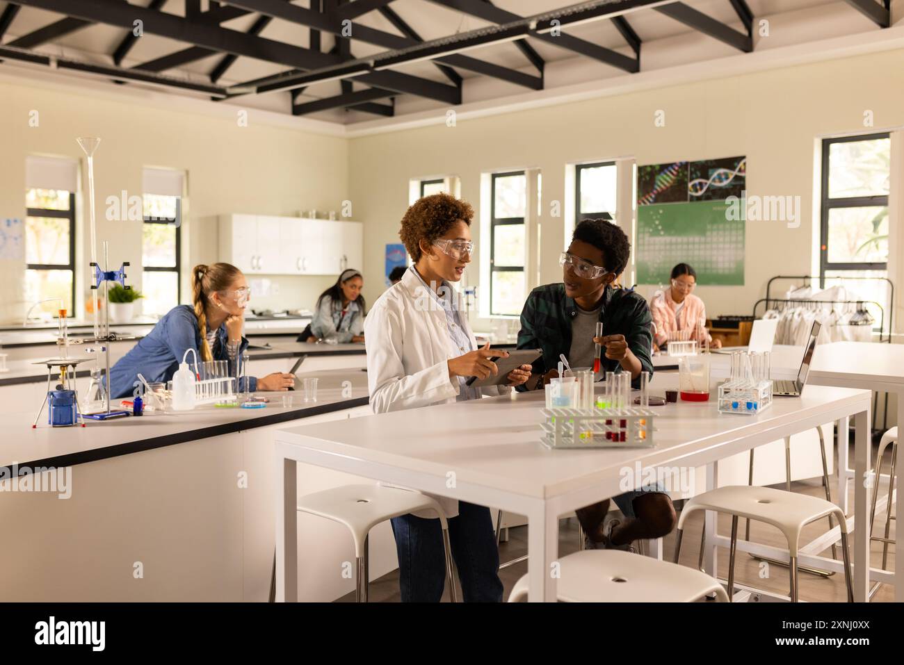 Conducting experiments and discussing results with classmates in high school laboratory Stock Photo
