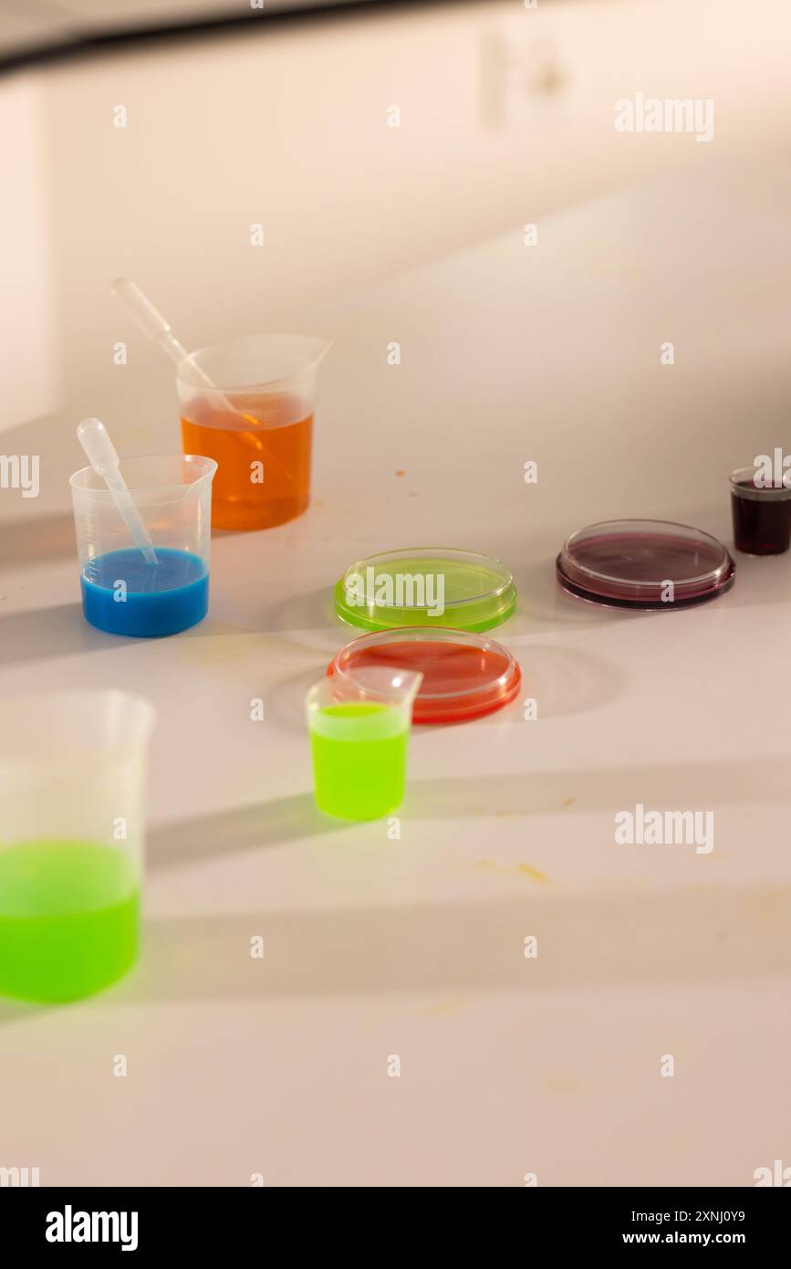 Science experiment in high school, colorful liquids in beakers on laboratory table Stock Photo