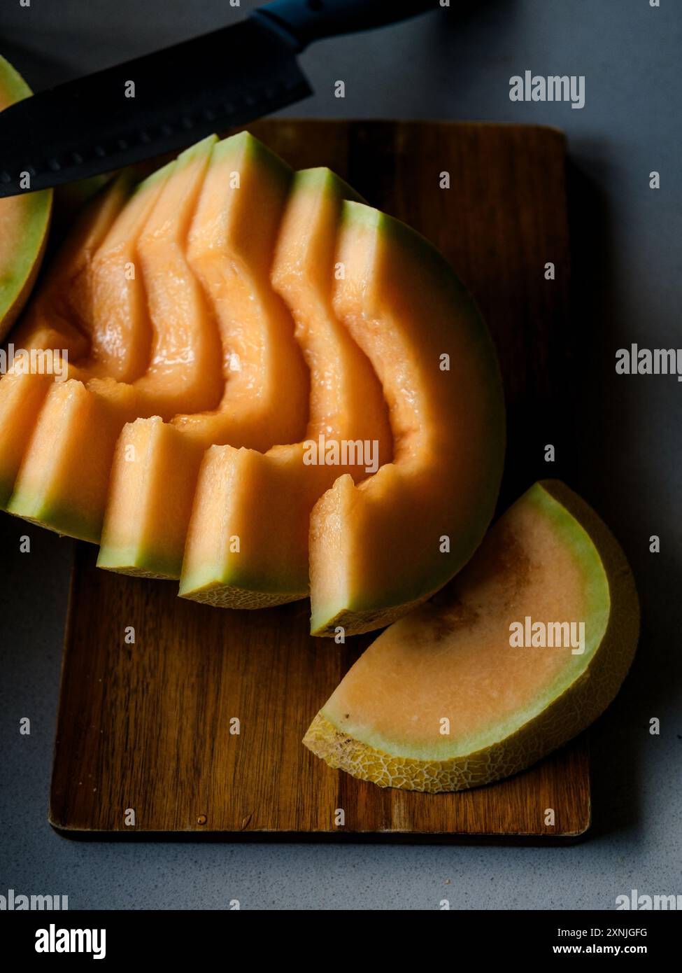 melon cut into slices on a cutting board Stock Photo