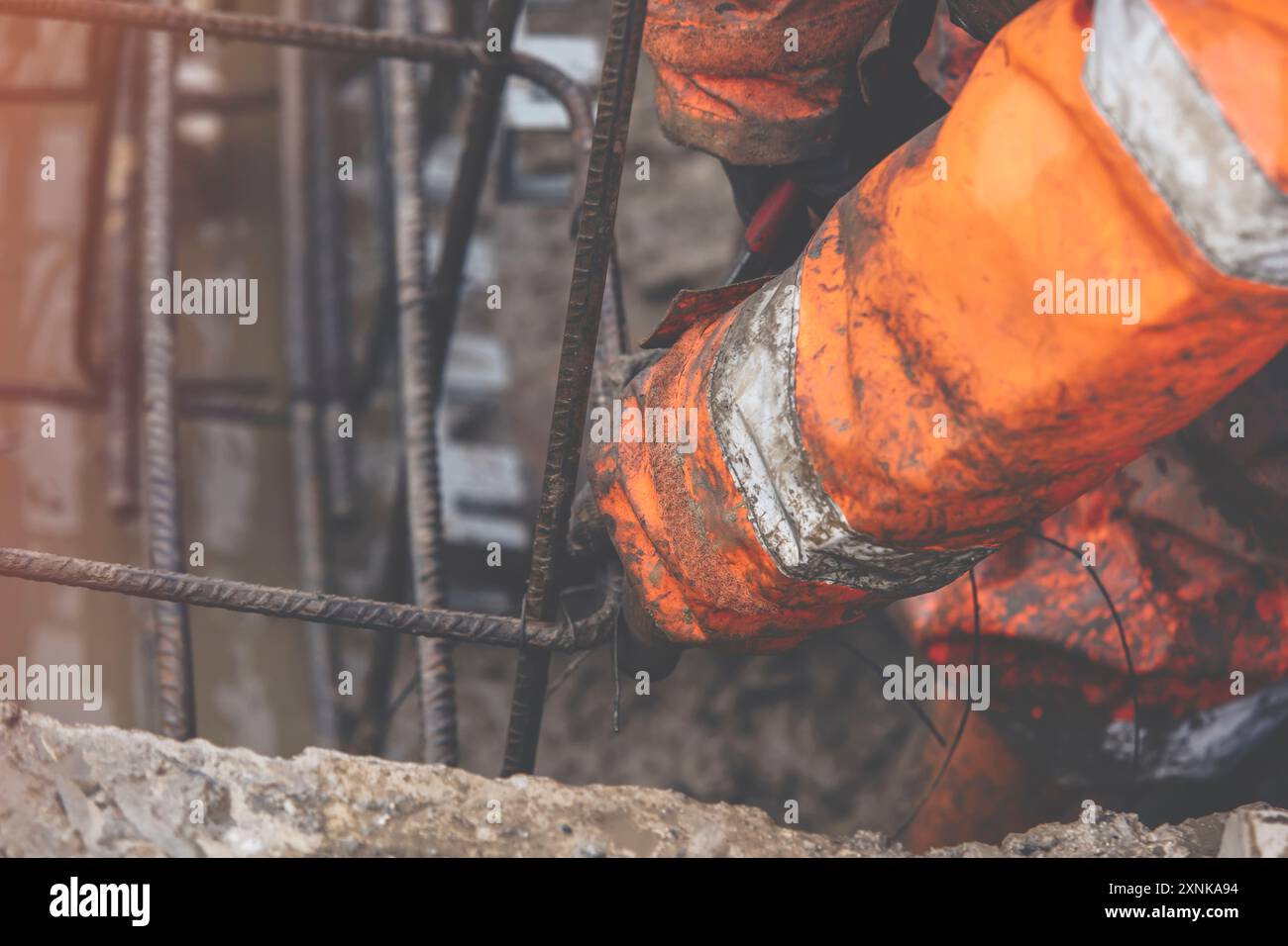 A worker uses steel tying wire to fasten steel rods to reinforcement ...