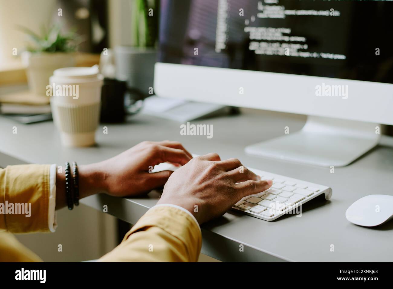 Medium closeup of hands of unrecognizable male programmer typing code ...