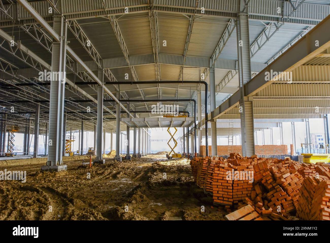 Construction site of a spacious warehouse with scaffolding and stacked ...