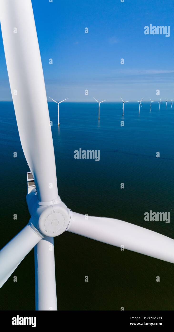 Turbines harnessing wind energy stand tall against the blue sky ...