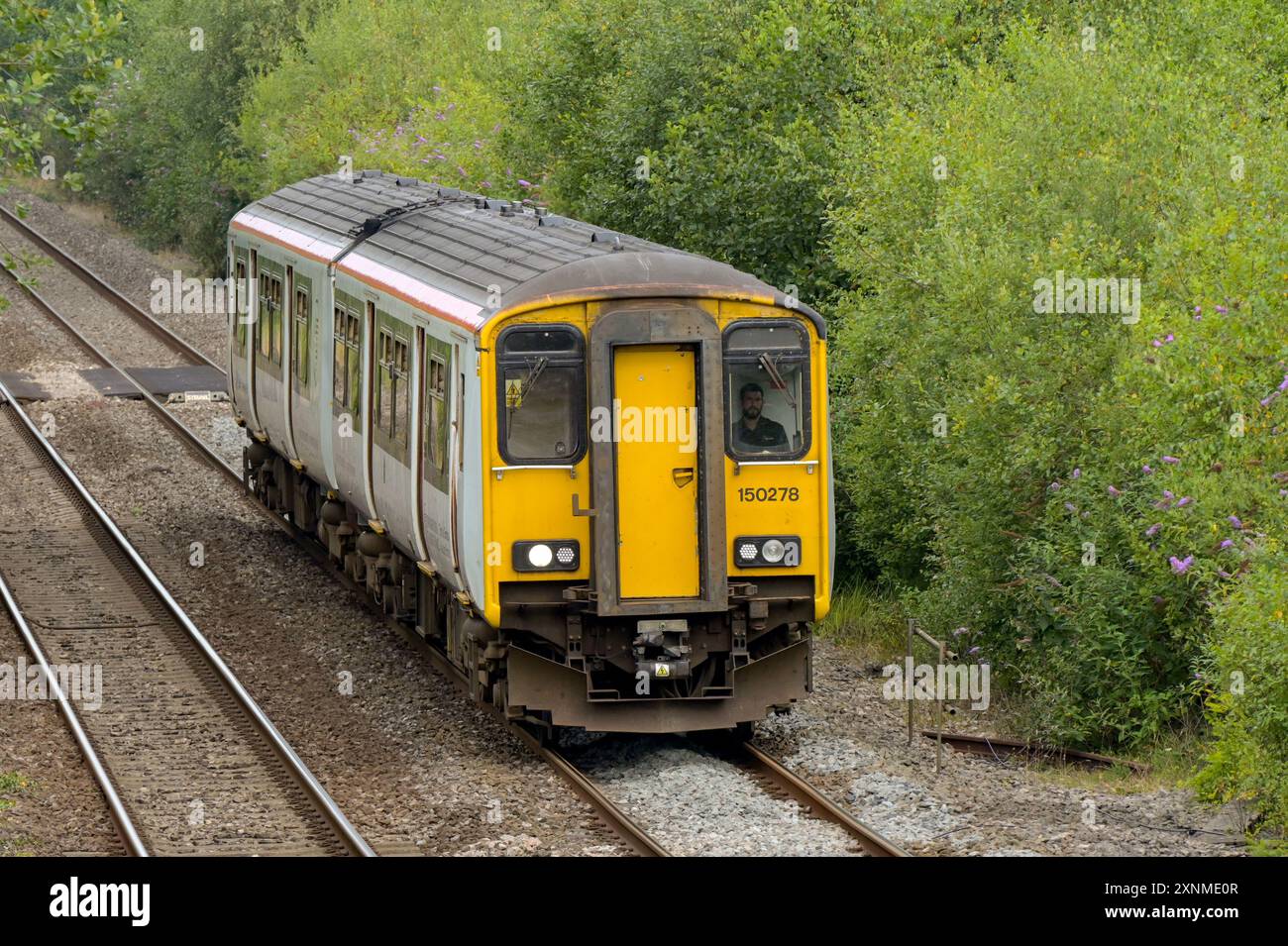 Pontyclun, Wales, UK. - 31 July 2024:  Class 150 diesel commuter train operated by Transport for Wales approaching the railway station in the village Stock Photo