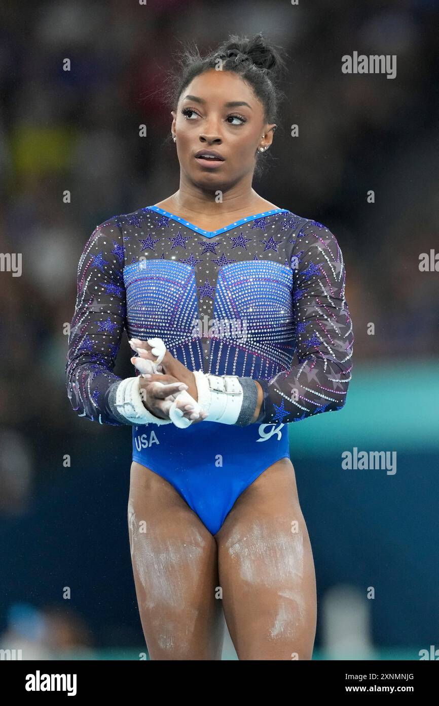 Simone Biles, of the United States, prepares to perform on the uneven ...