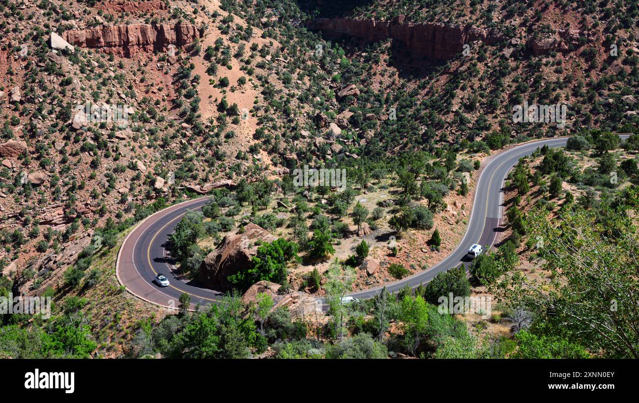 Traffic climbs Mount Carmel Highway Zion Park Boulevard around bend in road Stock Photo
