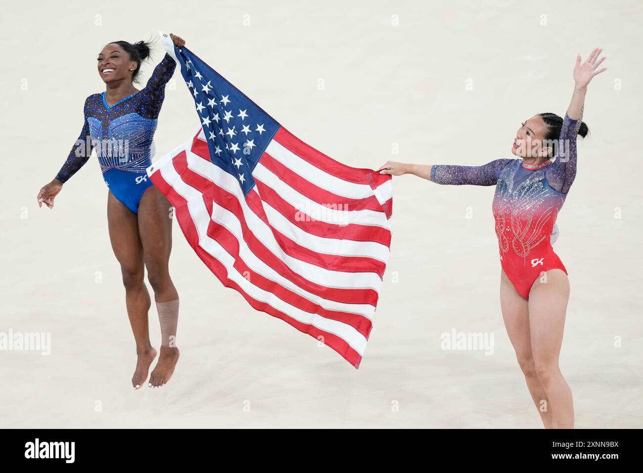 Simone Biles, left, celebrates after winning the gold medal with