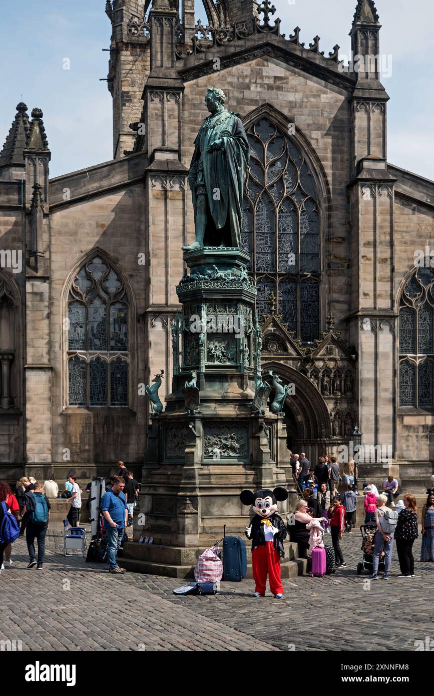 Statue of the Fifth Duke of Buccleuch and Mickey Mouse character outside St Giles Cathedral in West Parliament Square in Edinburgh's Old Town. Stock Photo