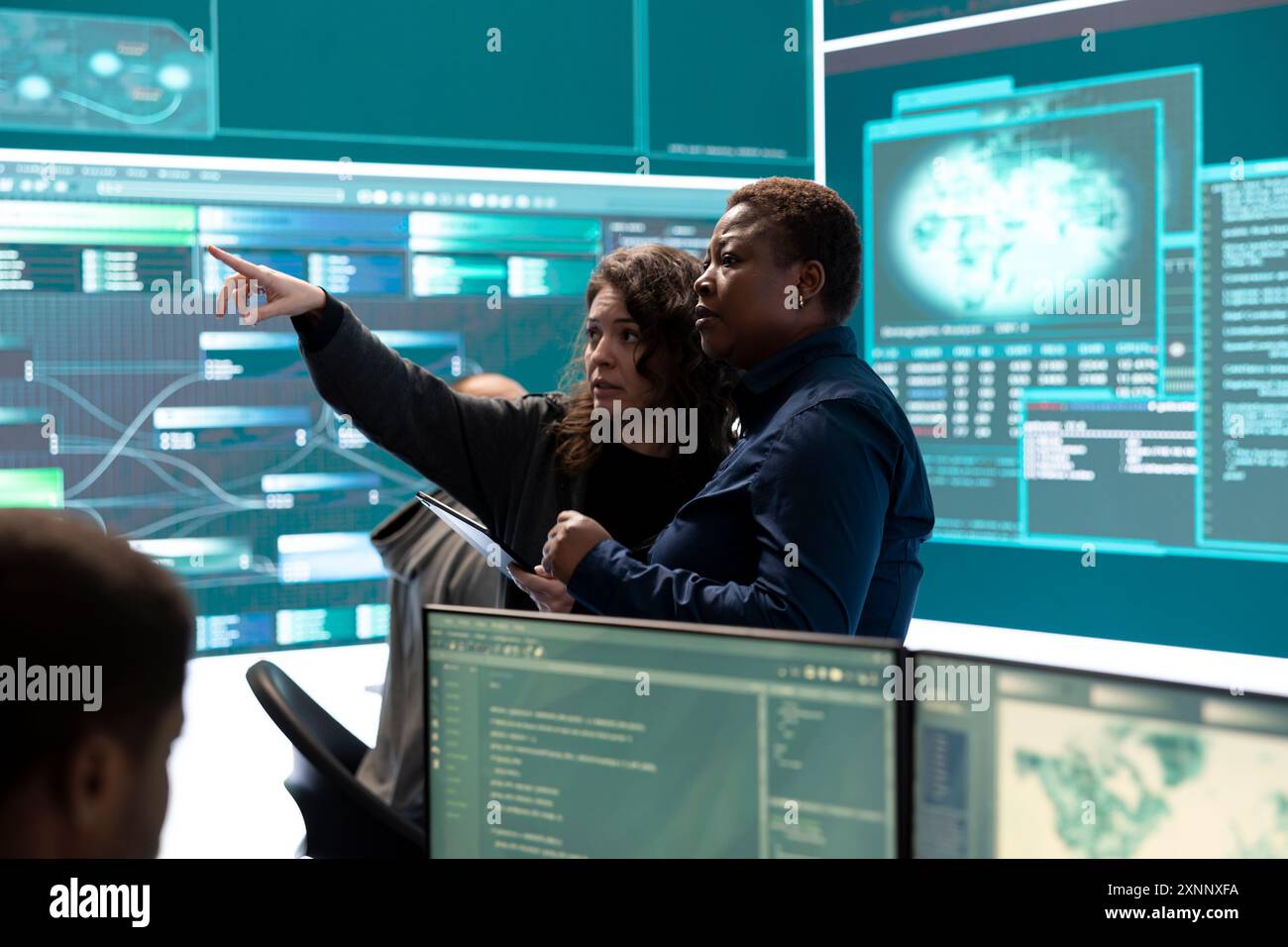 Governmental hackers analyzing cyber threats on big screens, managing important database hacking activity in high tech agency office. Work on cyber defense to protect national security. Stock Photo