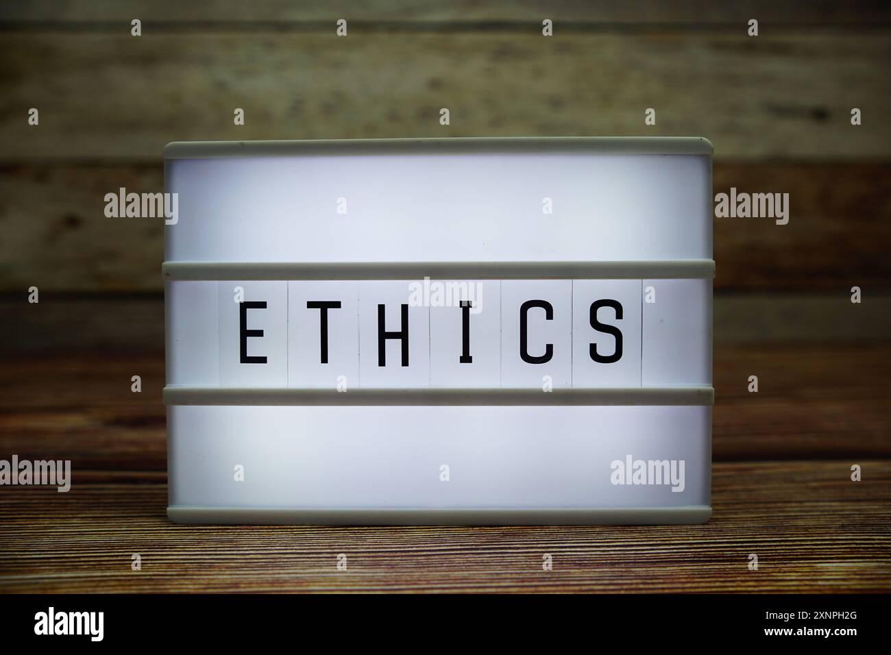 ETHICS letterboard text on LED Lightbox on wooden background, Business concept background Stock Photo