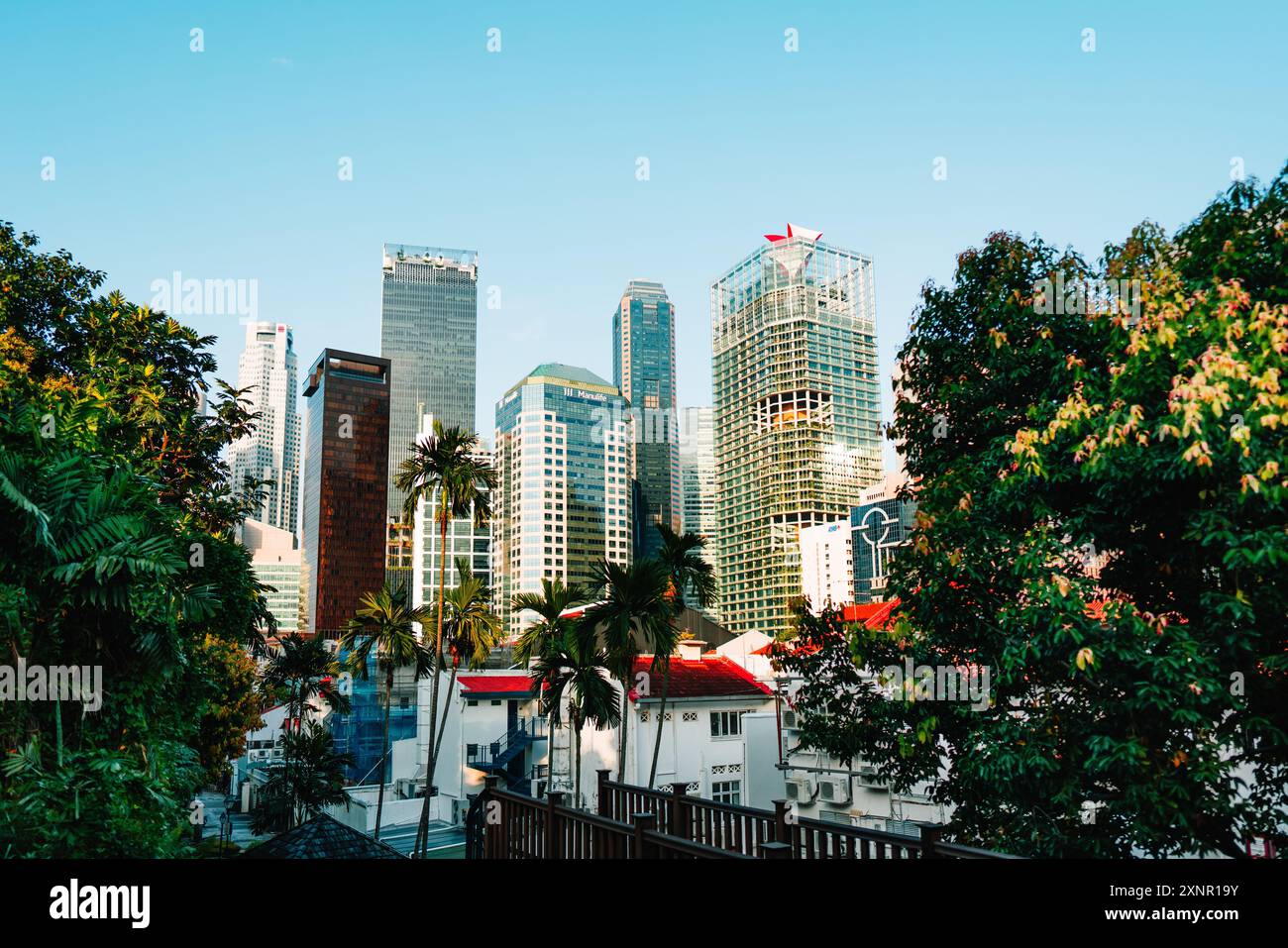 A vibrant cityscape of modern skyscrapers surrounded by lush greenery ...