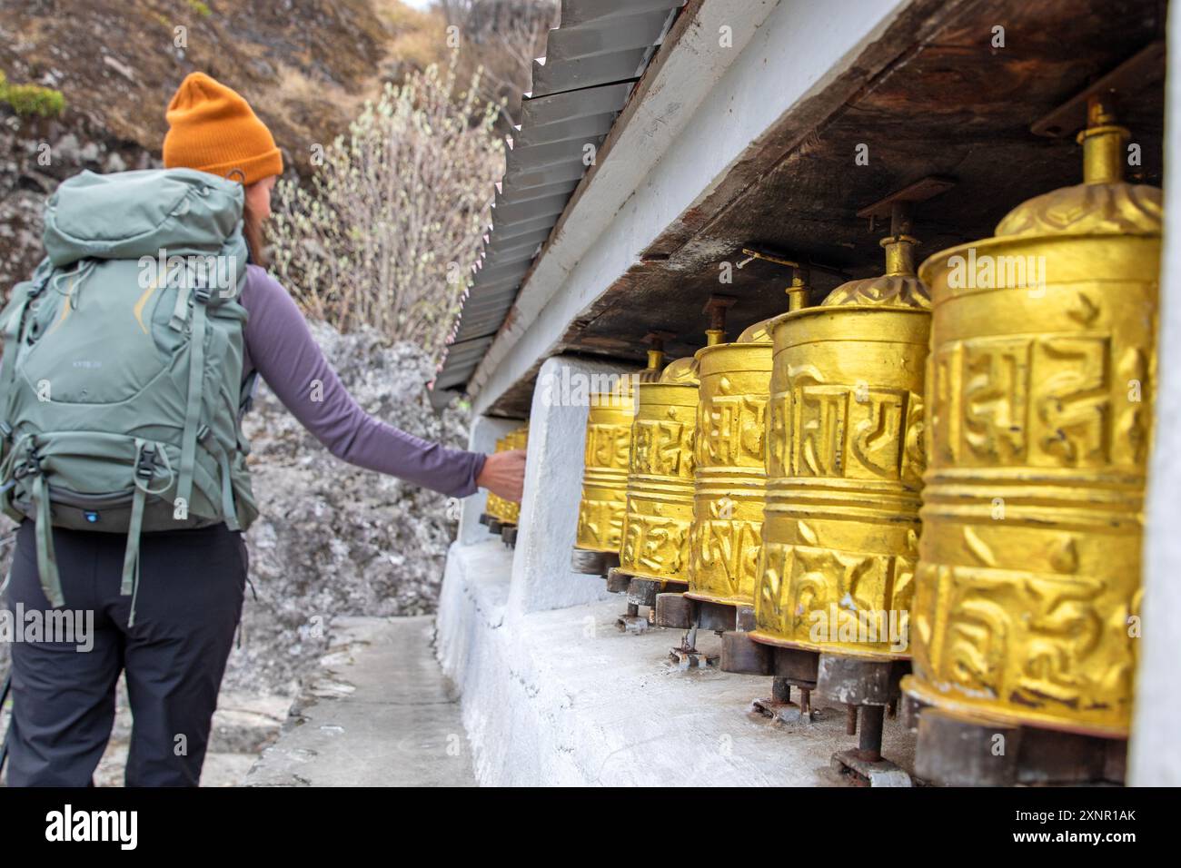Trekker spinning prayer wheels on the trek to Everest Base Camp Stock Photo