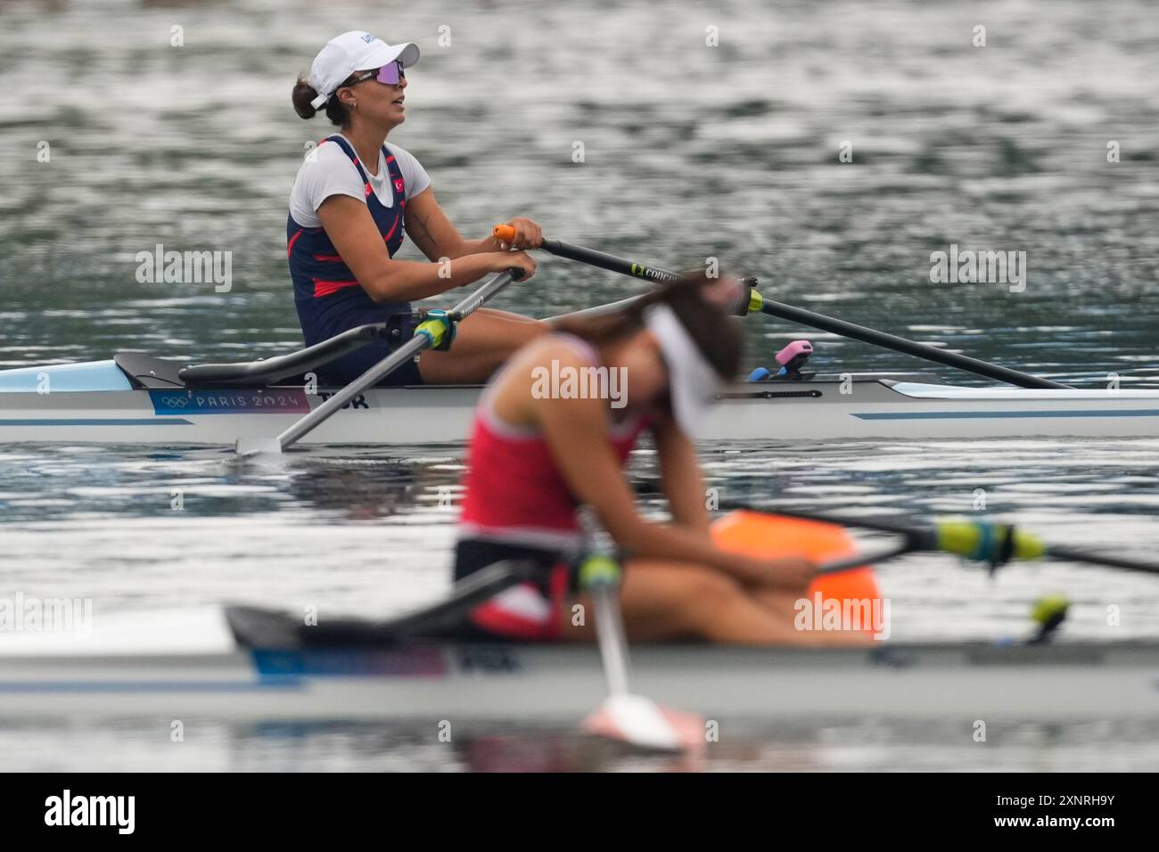 Elis Ozbay, of Turkey, back, reacts after the women's single sculls ...