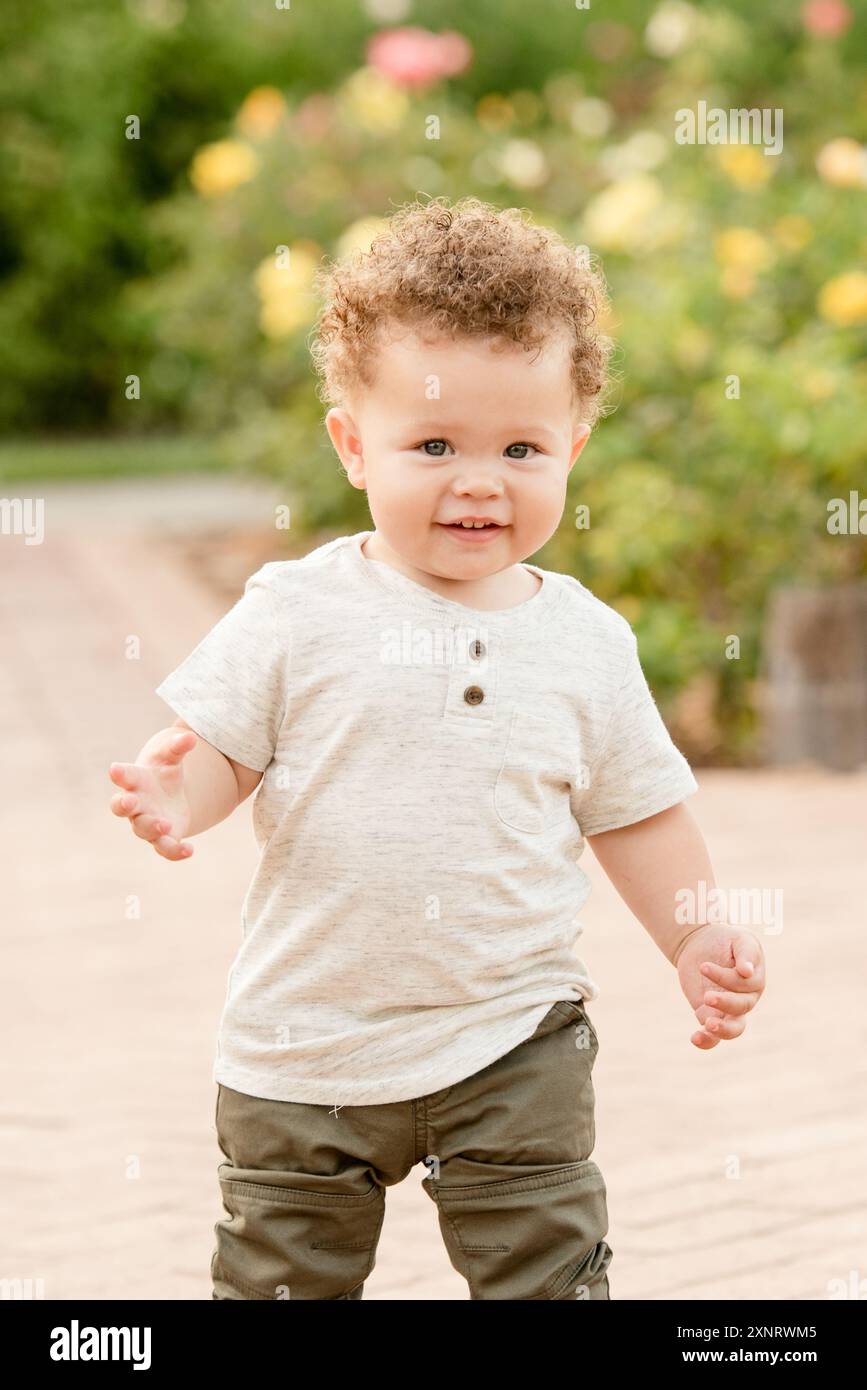 Baby walking in the garden of roses Stock Photo - Alamy
