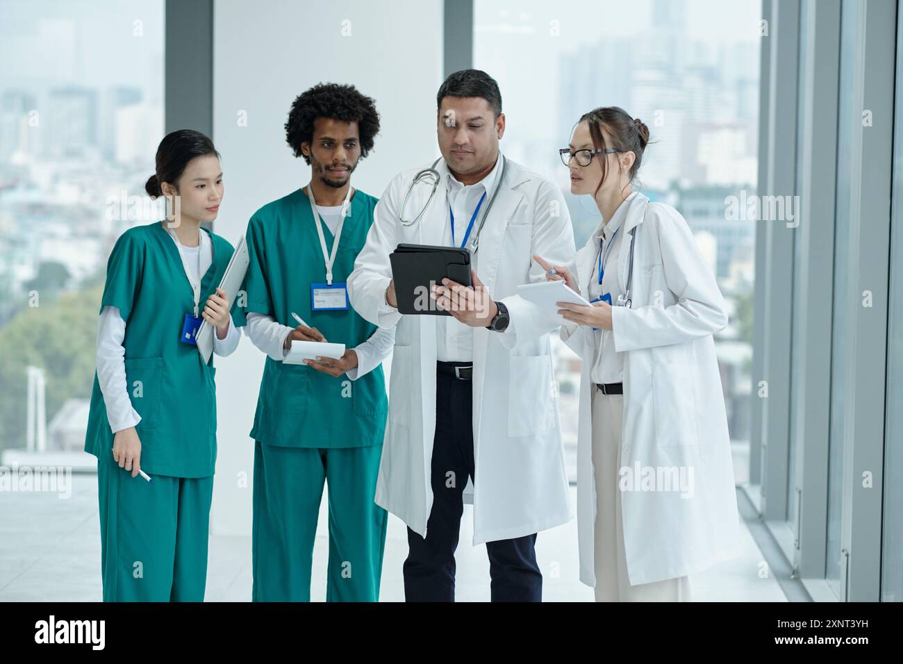 Doctor Using Tablet PC With Colleagues Stock Photo