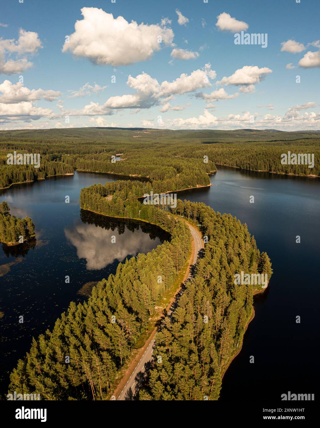 Aerial photo of a winding asphalt road across an esker in a lake in Dalarna, Sweden. Stock Photo