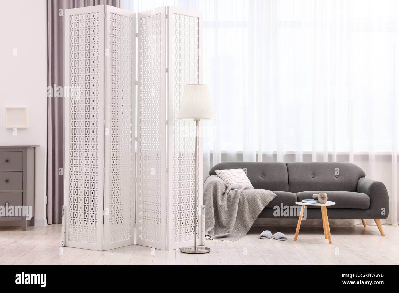 White folding screen, sofa, side table and lamp in living room Stock ...