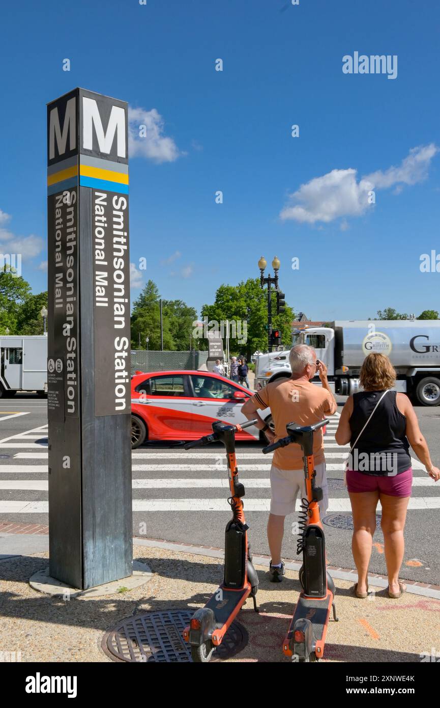 Washington DC, District of Columbia, USA - 1 May 2024: Two people waiting to cross the road at the Smithsonian Metro train station Stock Photo