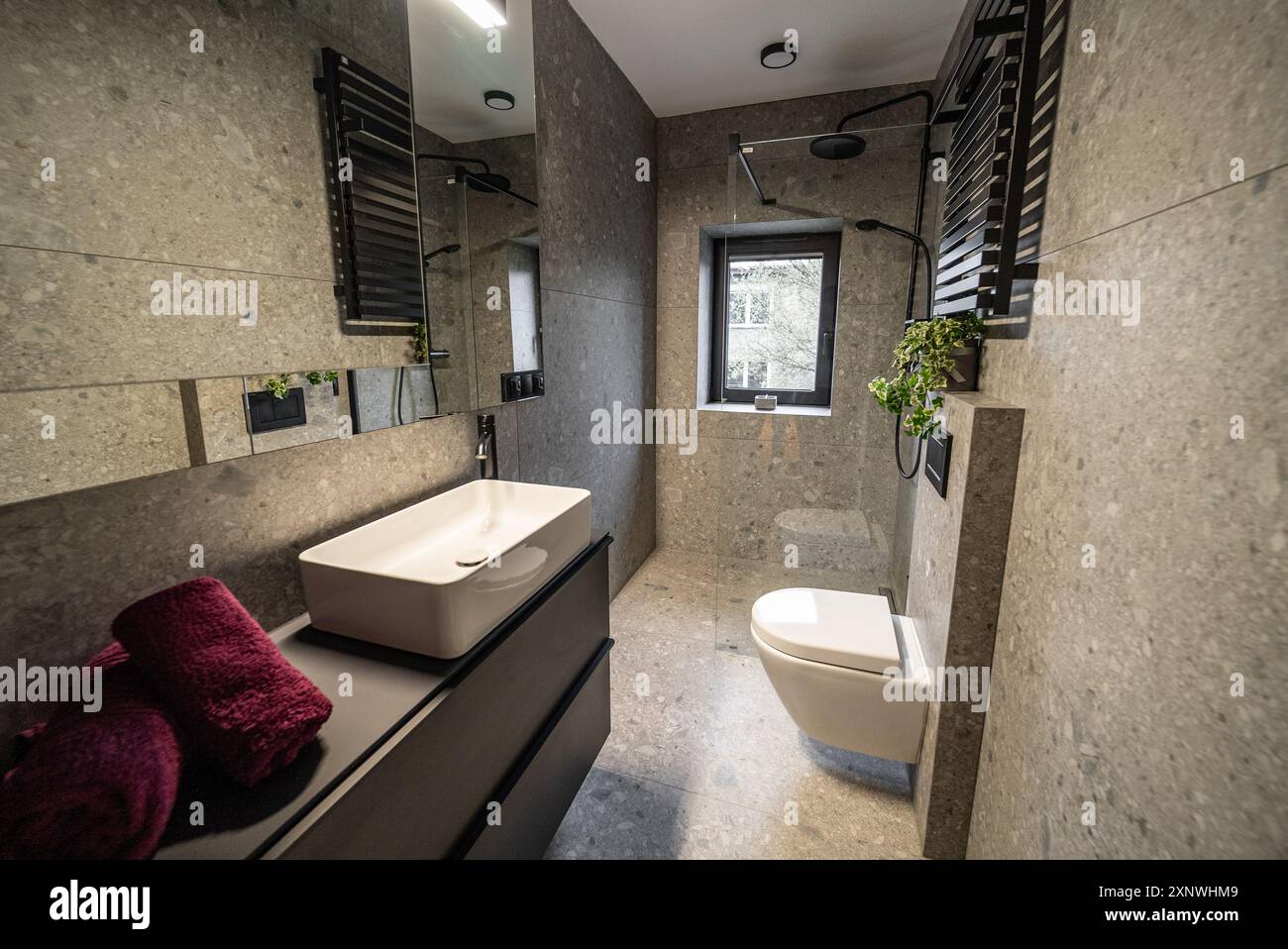 Interior of a modern bathroom featuring sleek tile walls and concrete ...