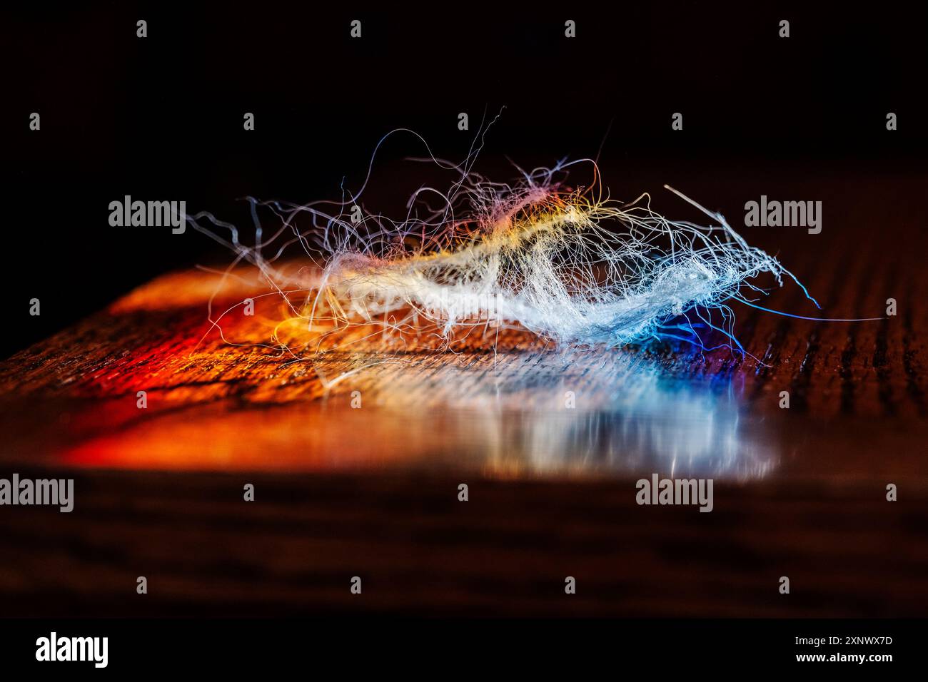 Refracted sunlight through stained glass window illuminates miscellaneous fiber threads Stock Photo