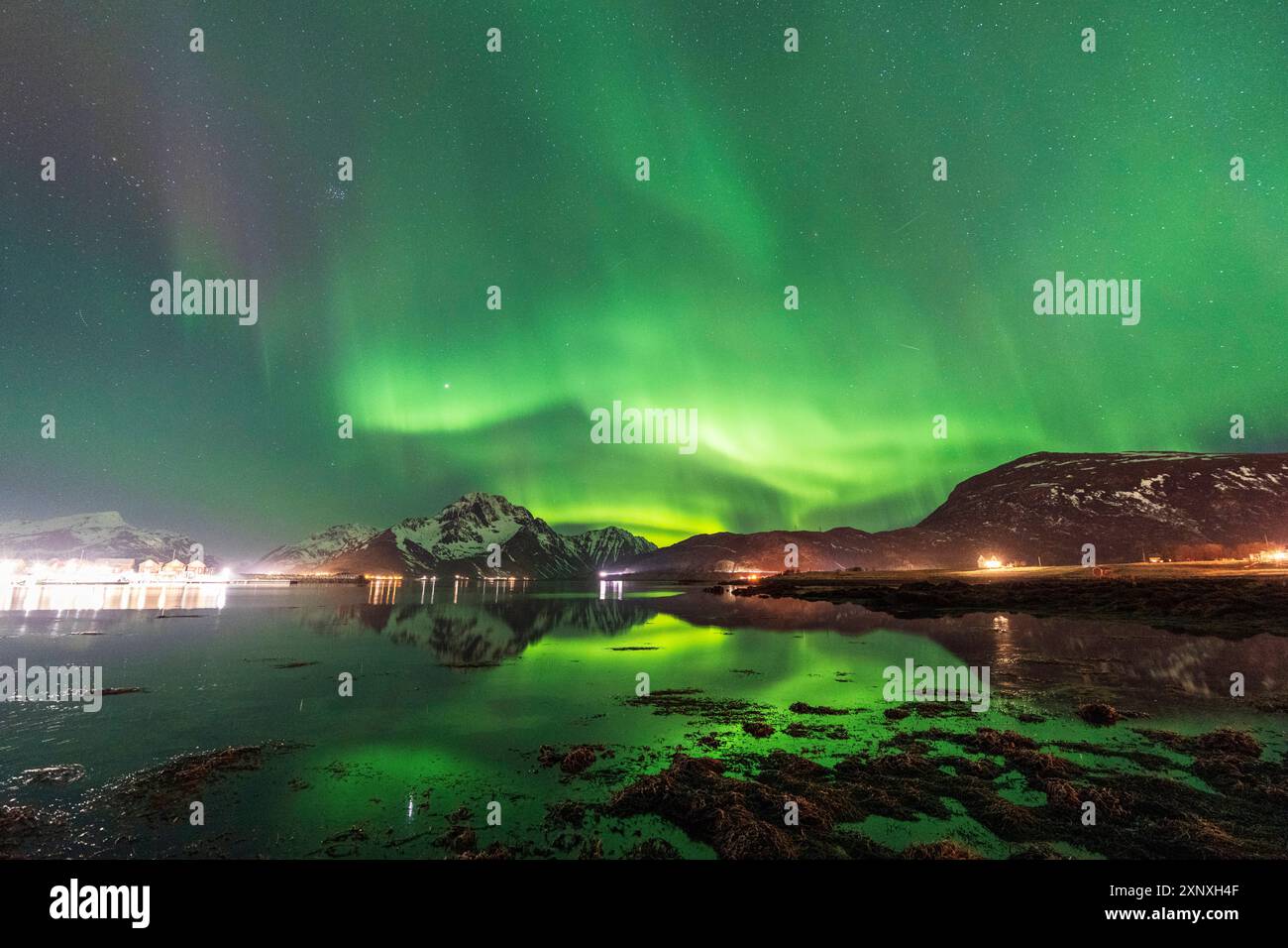 Northern lights Aaurora borealis on snowy mountains reflecting in the ...