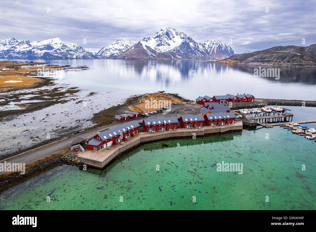 Traditional Rorbu Aerial view of traditional red rorbu surrounded by majestic mountains ...