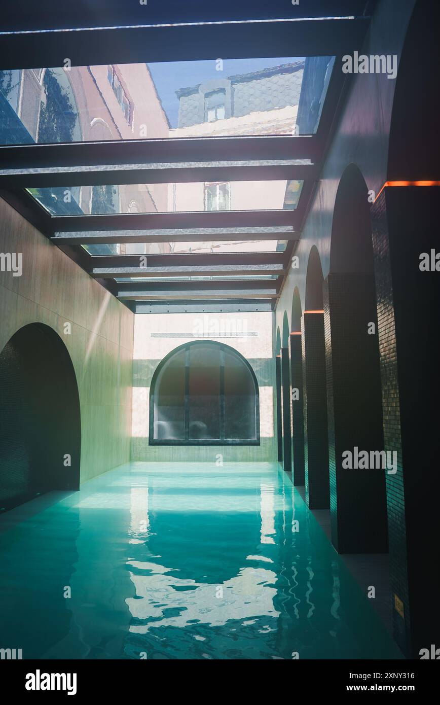 Luxurious Indoor Swimming Pool with Arched Doorways and Glass Ceiling ...