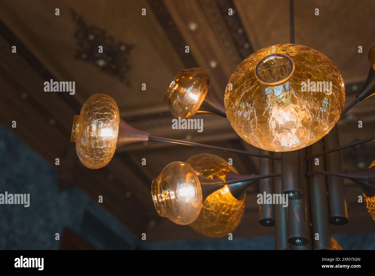 Luxurious Chandelier with Amber Glass Globes in Ornate Hotel Ceiling Stock Photo