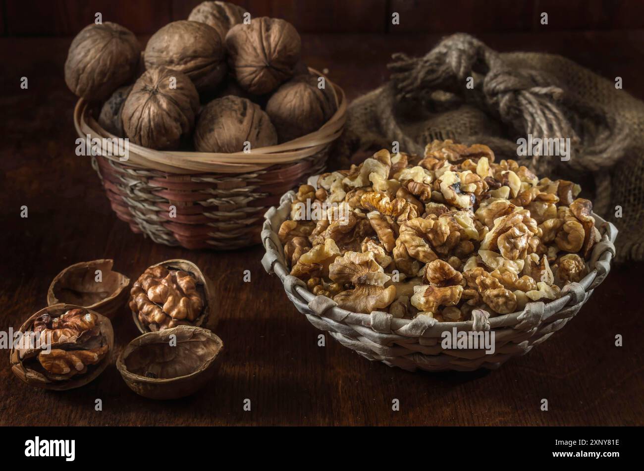 Walnuts and kernels in a basket on a dark wooden background Stock Photo