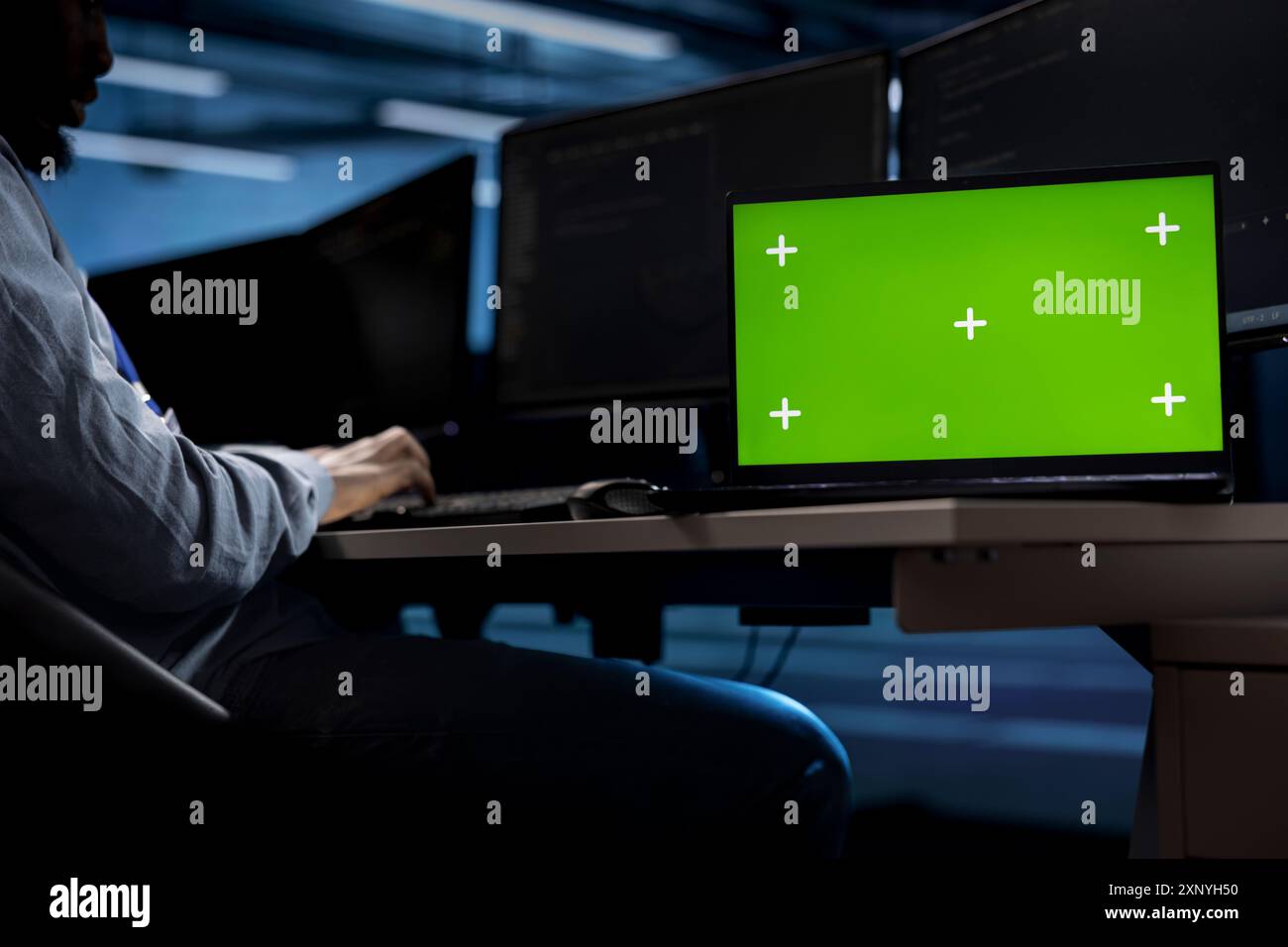 Engineer in server hub using isolated screen laptop to repair equipment storing datasets. Professional using chroma key notebook to do debugging on rigs doing computational operations Stock Photo