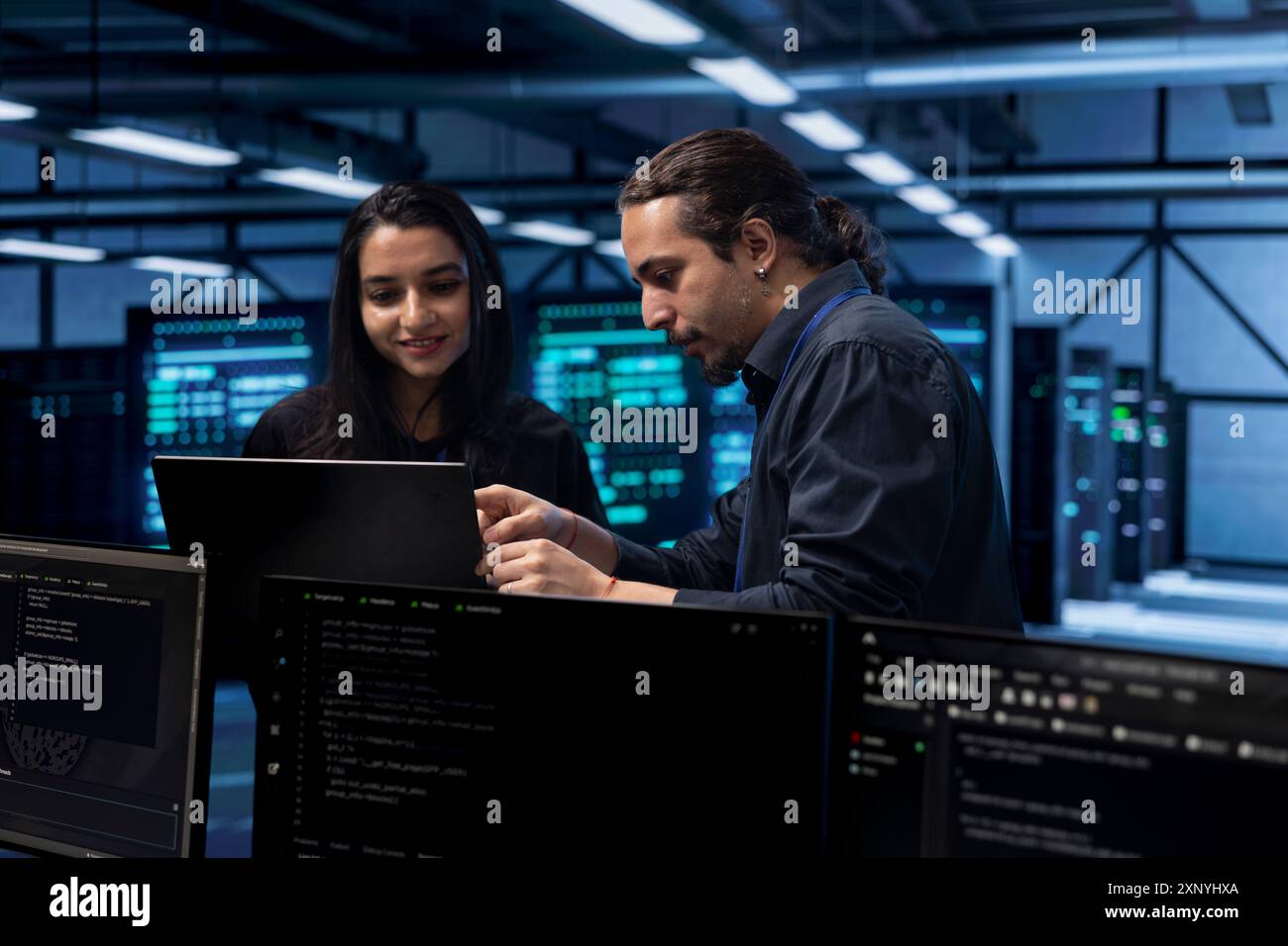 Programmers in data center using laptop to check for server performance issues, talking about solutions. Colleagues in server hub workplace fixing insufficient memory errors slowing down hardware Stock Photo