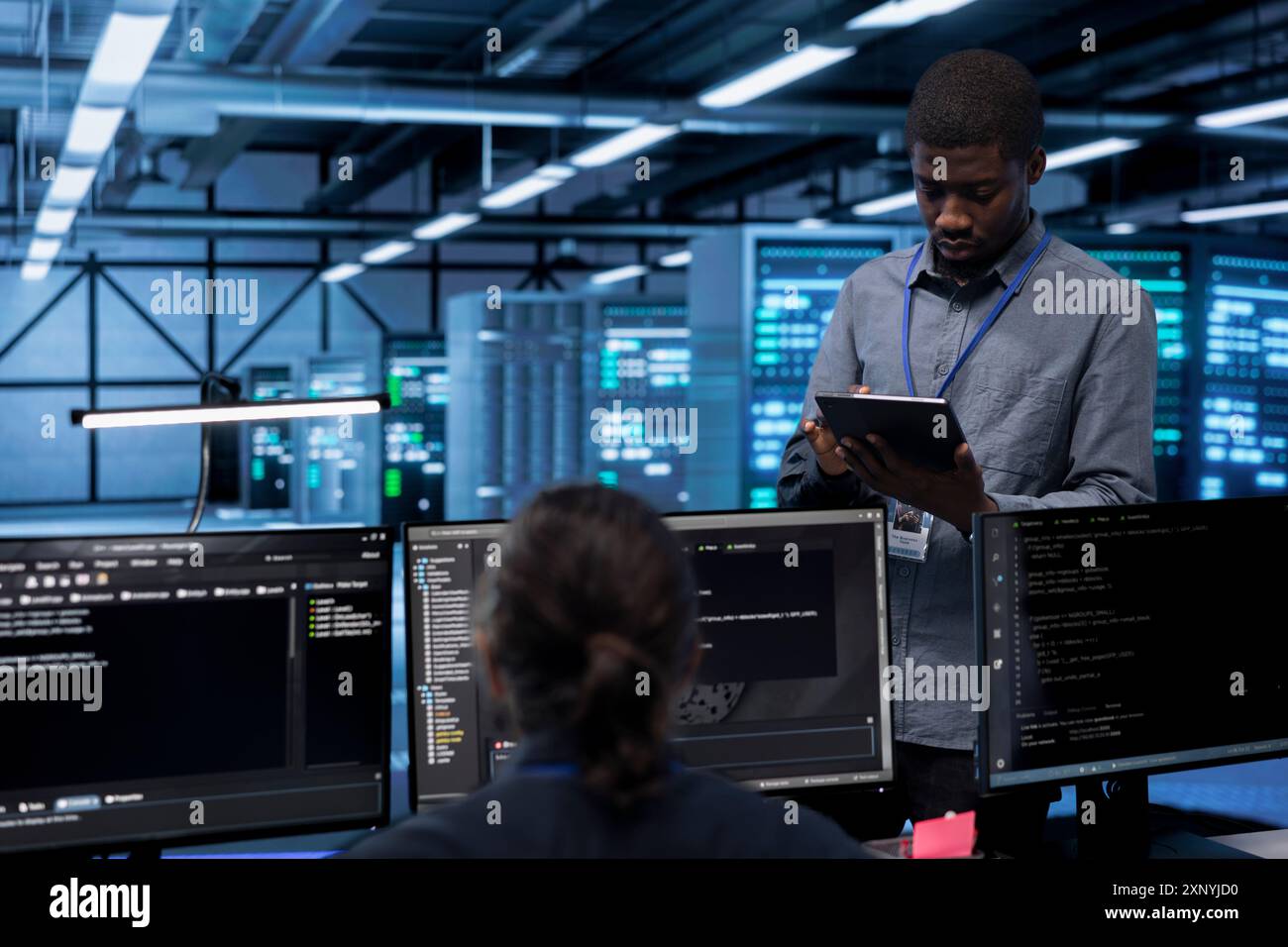 Engineer in data center running system diagnostic tests and error checking utilities to identify and resolve problems. Worker looking for network issues affecting server performance and connectivity Stock Photo