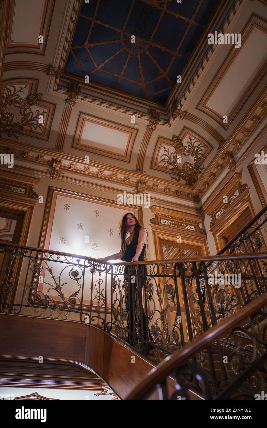 Elegant Woman on Ornate Wrought-Iron Staircase in Luxurious Hotel ...