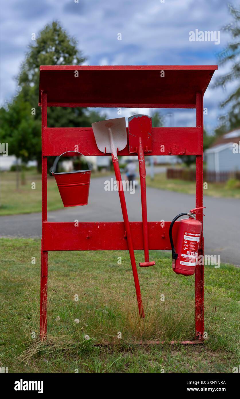 Rote Feuerlschstelle mit Feuerlscher, Schaufel, Spaten und Eimer auf  einem Campingplatz am Jersleber See Jersleben Sachsen-Anhalt Deutschland  *** Red fire extinguishing point with fire extinguisher, shovel, spade and  bucket on a campsite
