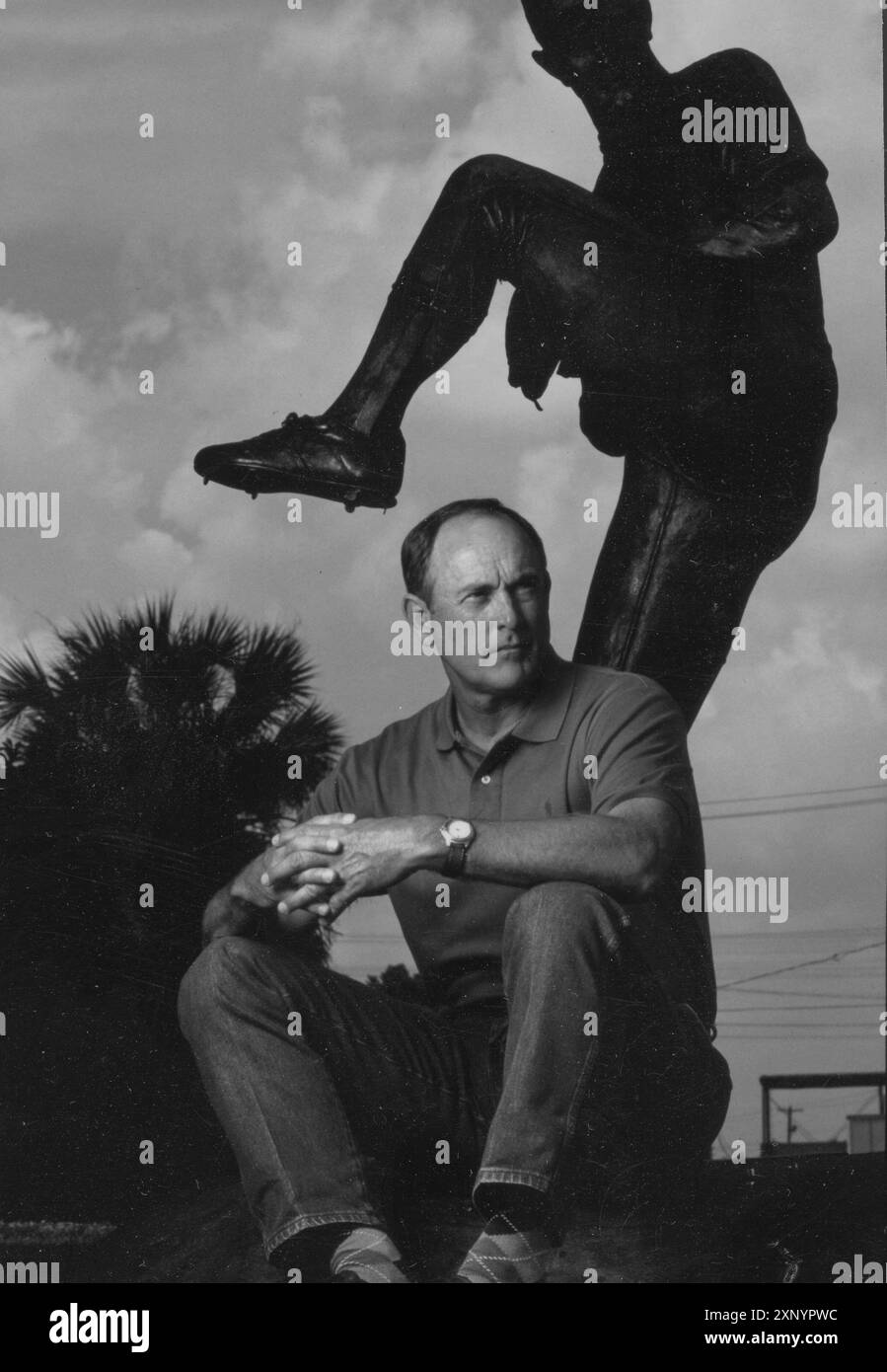 Baseball hall of fame pitcher NOLAN RYAN poses near a statue of himself pitching in Texas.  This was photographed for the 1995 All-Star program.  Original in color Stock Photo