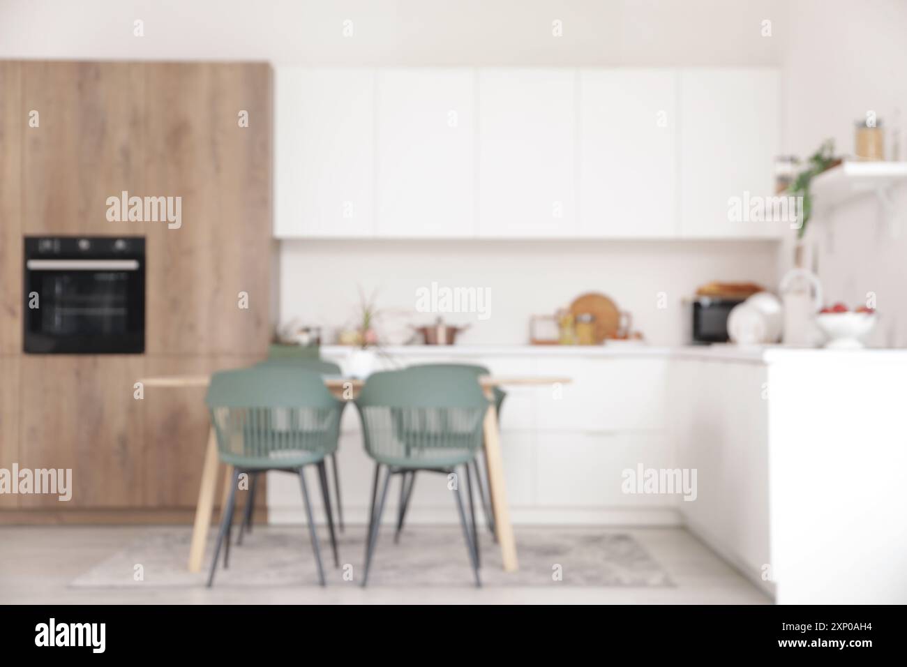 Blurred view of light kitchen with counters and dining table Stock ...