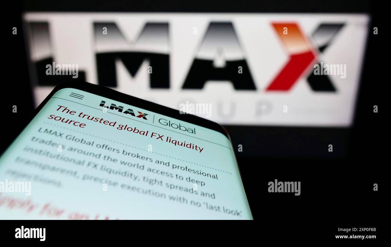 Stuttgart, Germany, 04-03-2022: Mobile phone with website of British fintech company LMAX Group on screen in front of business logo. Focus on Stock Photo