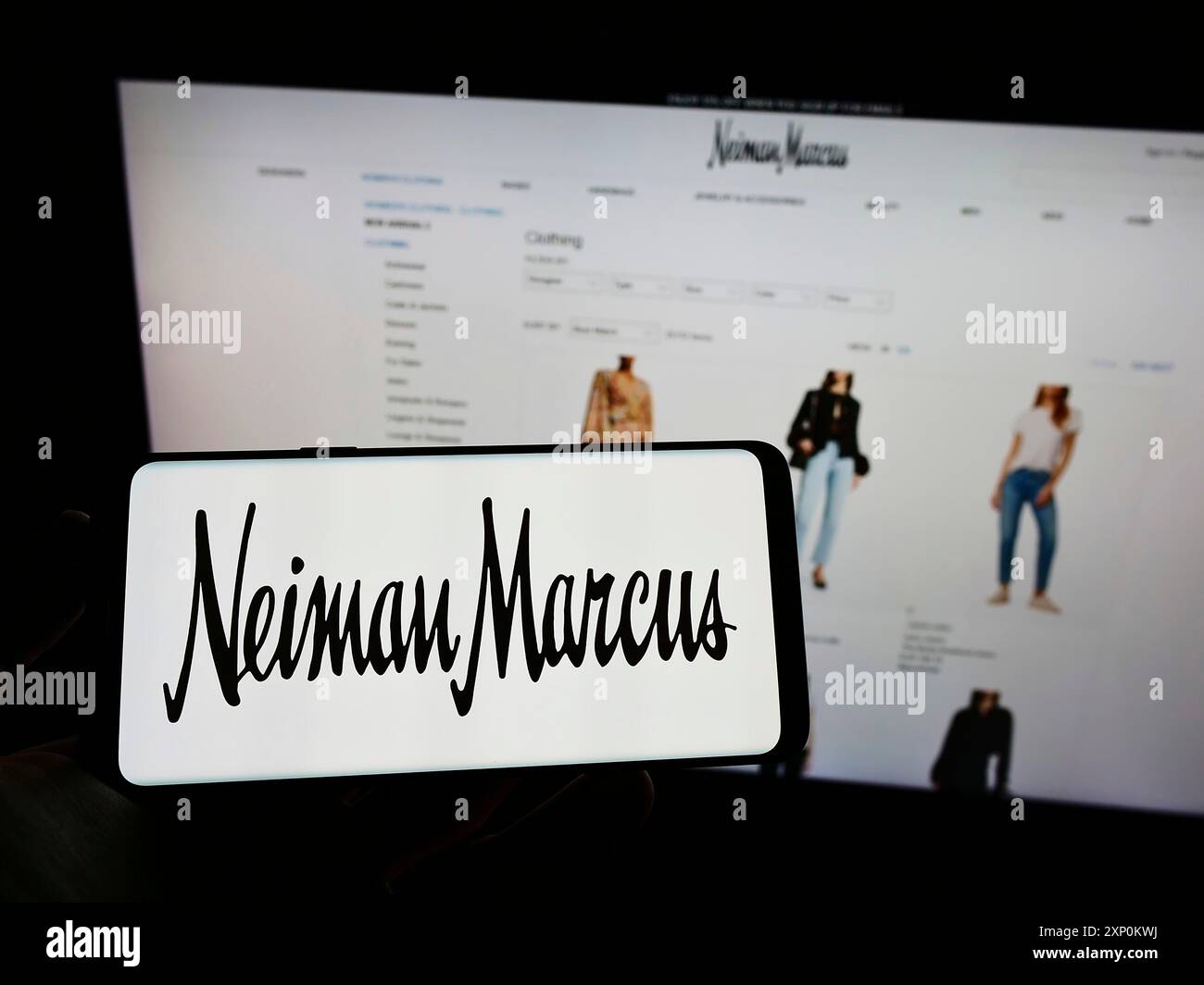 Stuttgart, Germany, 01-09-2022: Person holding mobile phone with logo of American luxury retailer Neiman Marcus Group Inc. on screen in front of web Stock Photo