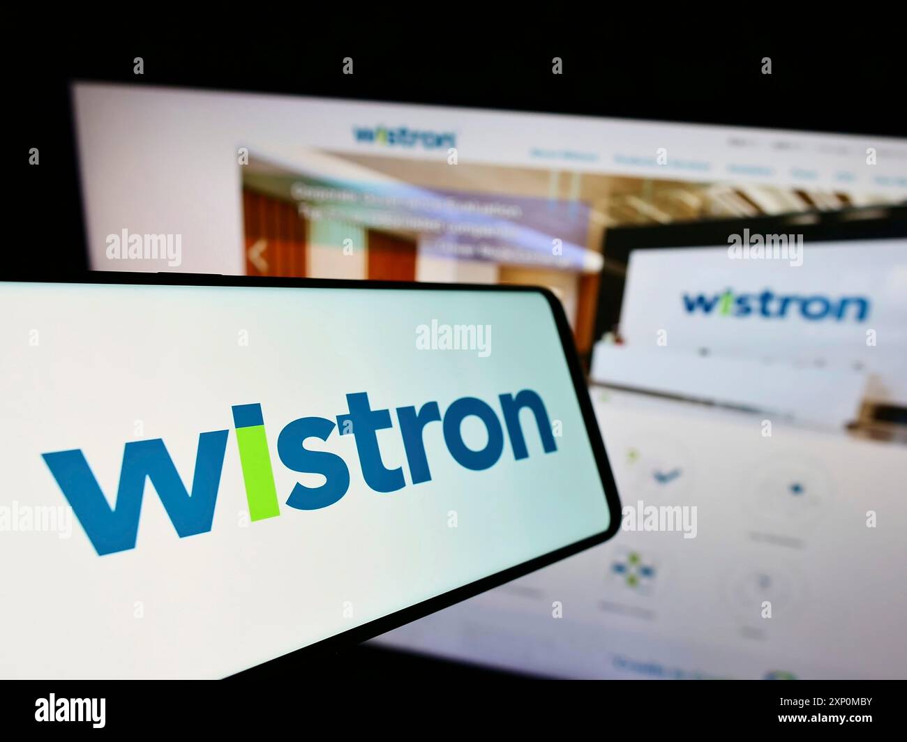 Stuttgart, Germany, 01-06-2022: Mobile phone with logo of Taiwanese electronic company Wistron Corporation on screen in front of website. Focus on Stock Photo