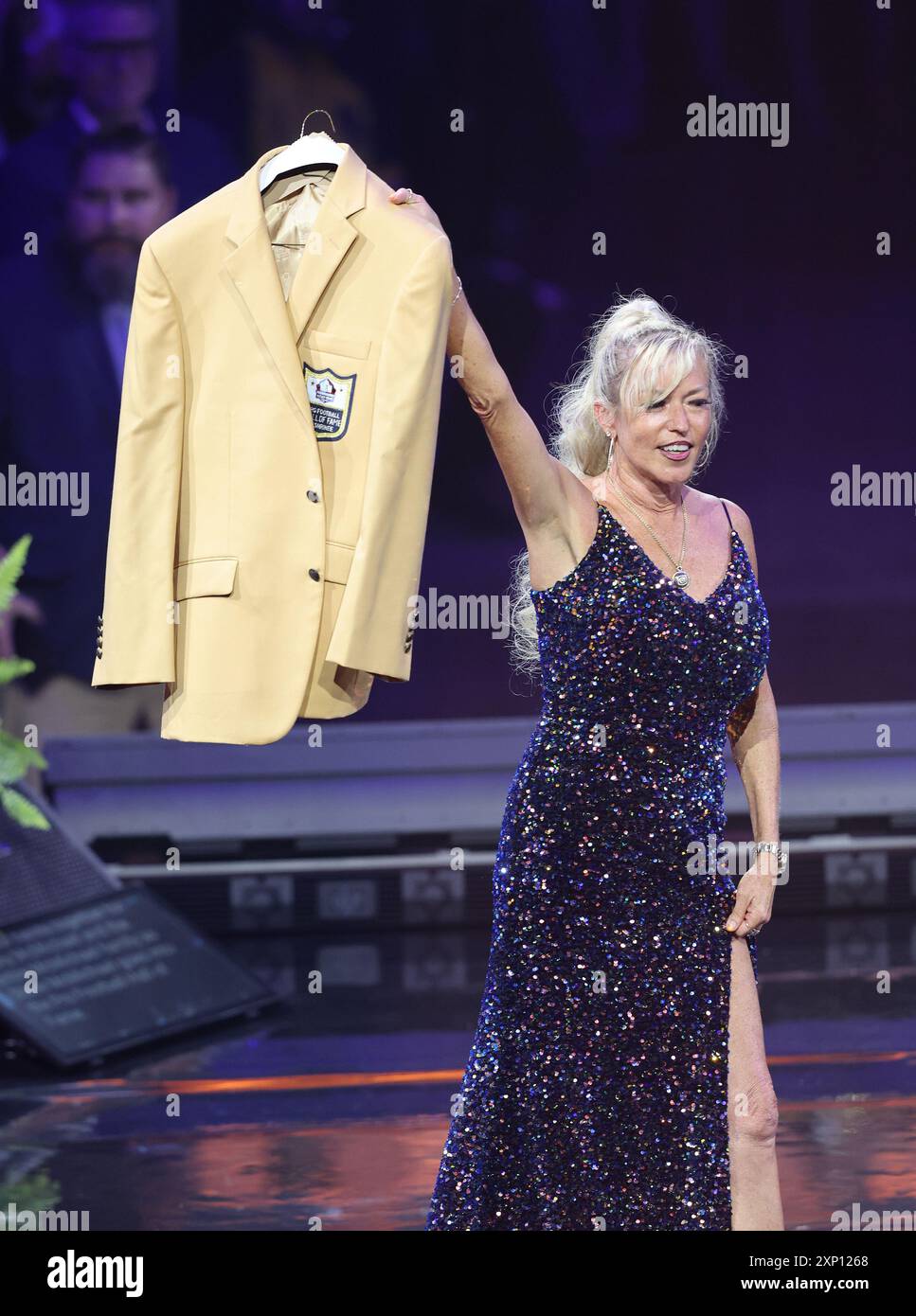 Canton, United States. 02nd Aug, 2024. Misty McMichael, wife of 2024 Pro Football Hall of Fame inductee Steve McMichael holds up her husbands gold jacket during a ceremony in Canton, Ohio, on Canton, United States. 02nd Aug, 2024. Misty McMichael, wife of 2024 Pro Football Hall of Fame inductee Steve McMichael holds up her husbands gold jacket during a ceremony in Canton, Ohio, on
