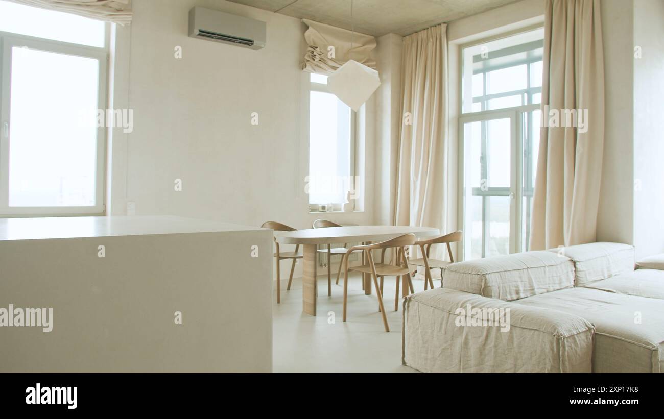 Modern interior design of open space with adjustable sofa, furniture, wooden coffee tables, patterned bedspreads, pillows, and stylish personal access Stock Photo