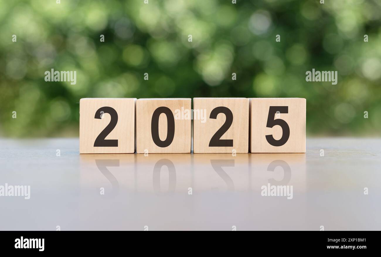 Wooden Blocks Spelling Out 2025 on Table With Green Background Stock Photo
