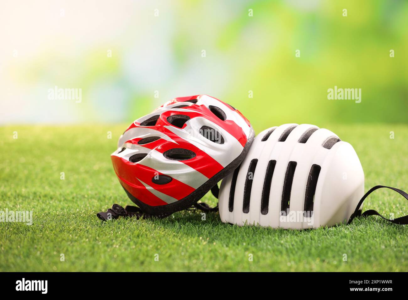 Two protective helmets on green grass, space for text Stock Photo - Alamy