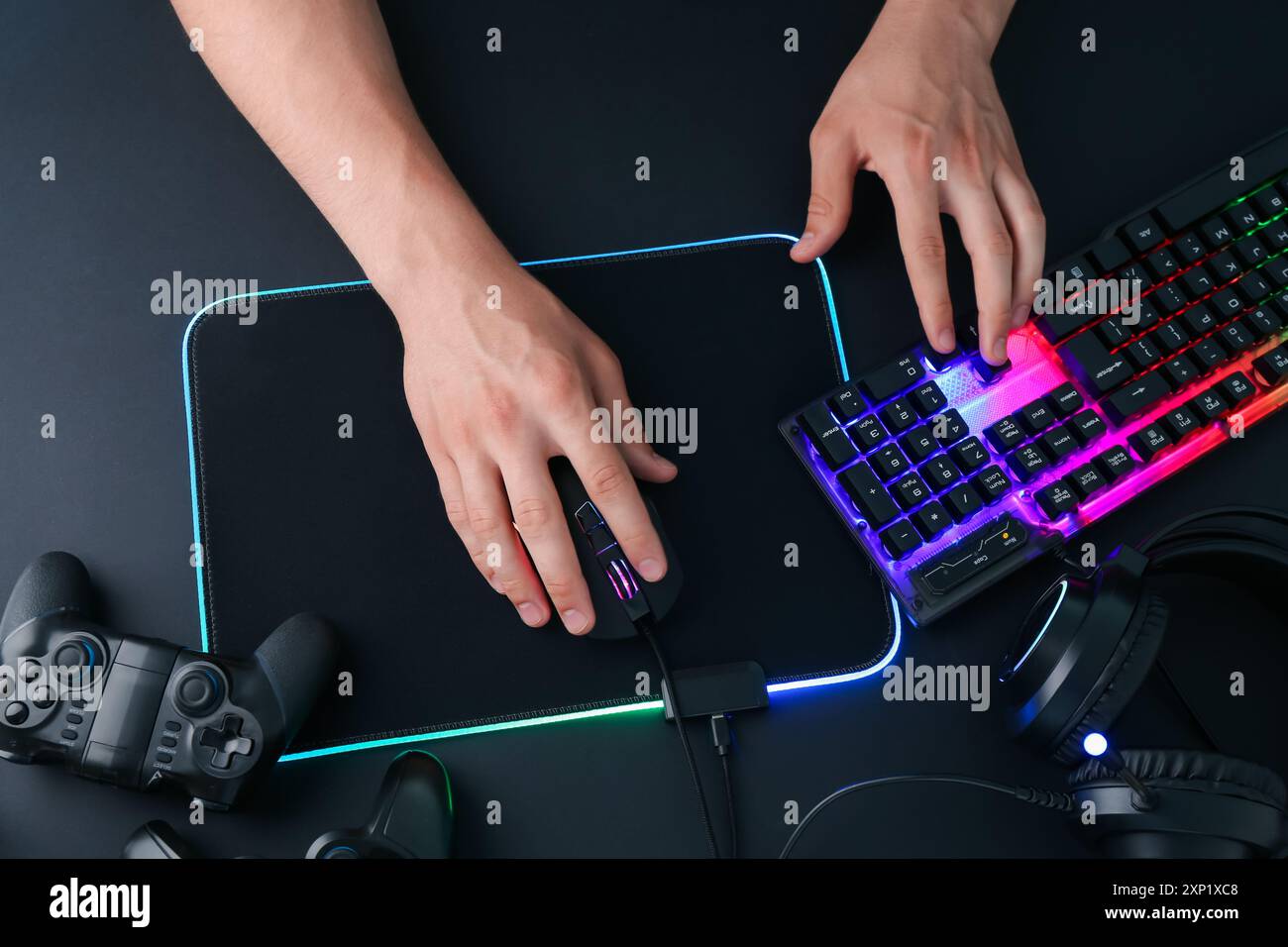 Gamer using modern wired computer mouse at black table, top view Stock Photo