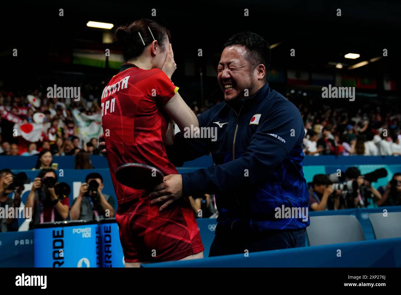 Japan's Hina Hayata, left, with her coach, celebrates after defeating ...