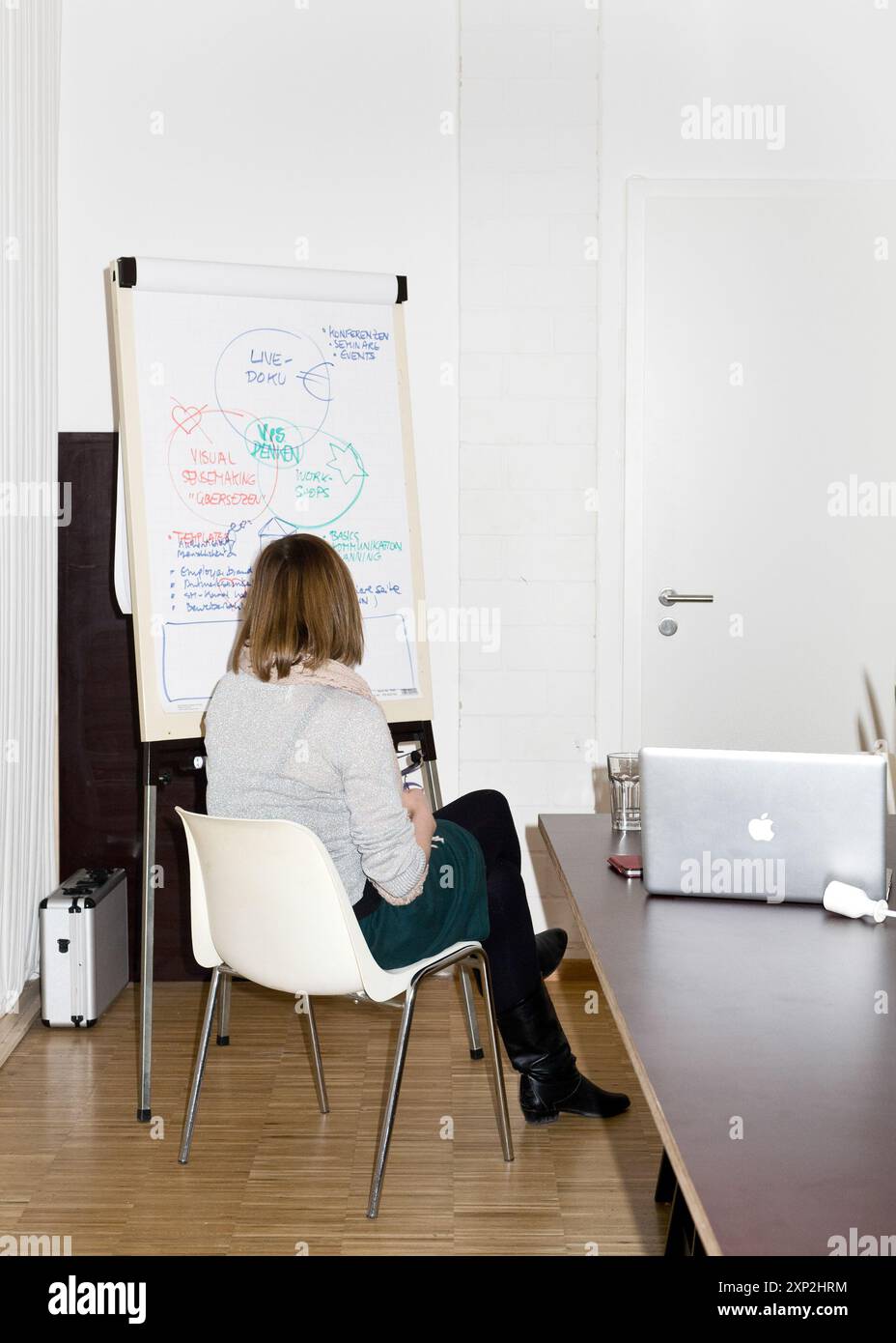 Woman creating ideas on a flip chart in a collaborative brainstorming ...